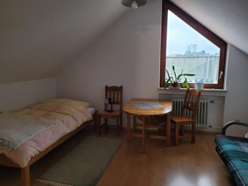 1 dormitorio con cama, mesa y ventana en Ferienwohnung Schöneck, en Tettnang