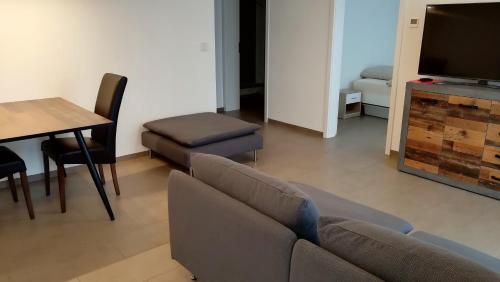 een woonkamer met een bank, een tafel en een televisie bij Apartment mit Terrasse in Abstatt in Abstatt