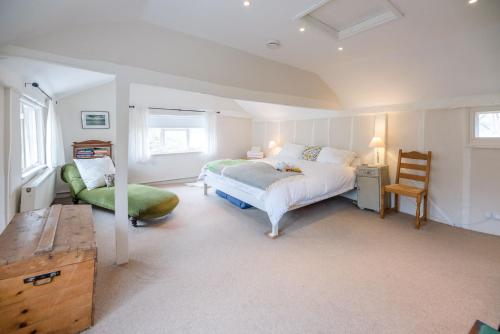 a bedroom with a large bed and a chair at Ivy House Mells in Halesworth