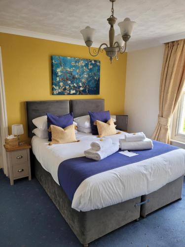 a bedroom with a large bed with towels on it at The Birdham At Bembridge in Bembridge