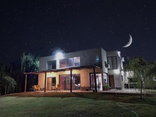 Una casa di notte con la luna nel cielo di Casa de Campo Finca La Angelita a Tunuyán