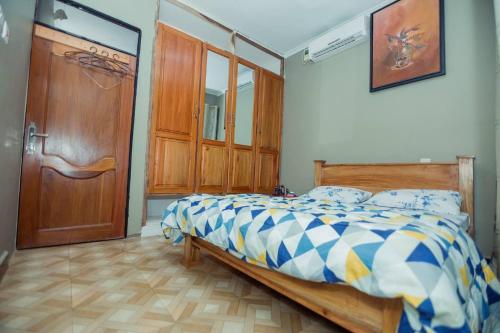 a bedroom with a bed and a wooden door at Stunning 2-Bed Apartment in Moshi Town in Moshi
