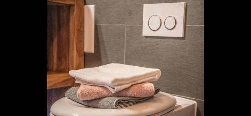a pile of towels sitting on top of a toilet at Hirsch Chalet #Sauna in Lechbruck