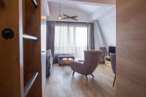 a living room with a chair and a table at Pano Kopaonik Panorama in Kopaonik