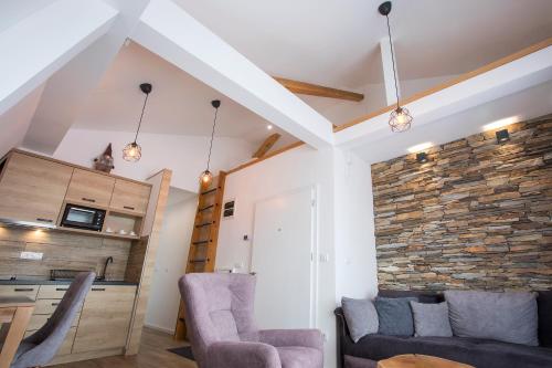 a living room with two chairs and a stone wall at Pano Kopaonik Panorama in Kopaonik