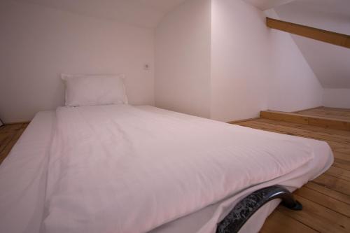 a white bed in a small room with a staircase at Pano Kopaonik Panorama in Kopaonik