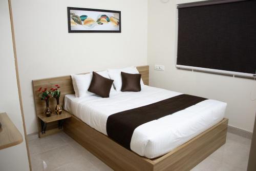 Schlafzimmer mit einem Bett mit einer schwarzen und weißen Bettdecke in der Unterkunft Richinn Palace home stay in Chennai