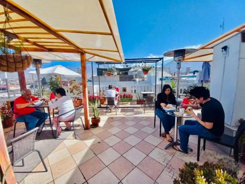 a group of people sitting at tables on a patio at Maison verte - Guest House in Arequipa