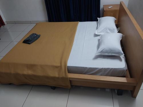 a bed with a wooden frame and two pillows on it at lloydskochi home stay in Cochin