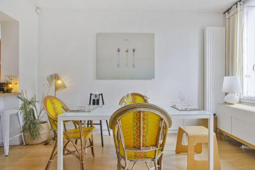 comedor con mesa blanca y sillas amarillas en Maison de l'Ermitage - Welkeys en Le Bouscat