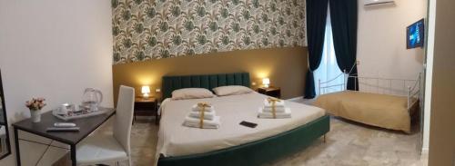 a bedroom with a bed and a table and a bed sidx sidx sidx at PANORAMICO in Catania