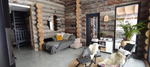 a living room with a couch and a wooden wall at Upea kelohirsihuvila rannalla, myös poreamme! in Joensuu