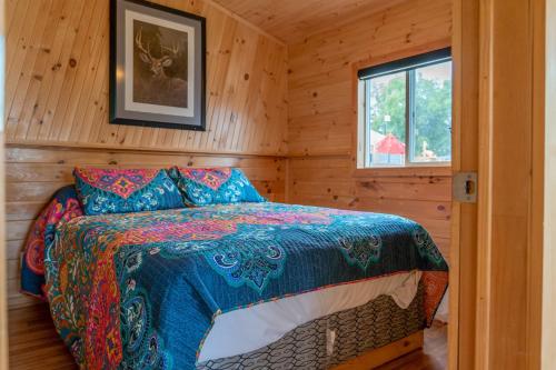 Un dormitorio con una cama en una cabaña de madera. en Stoneburg Cove Cottages, en Carrying Place