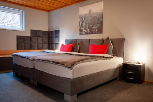 a bedroom with a large bed with red pillows at Moving Rooms in Wimpassing