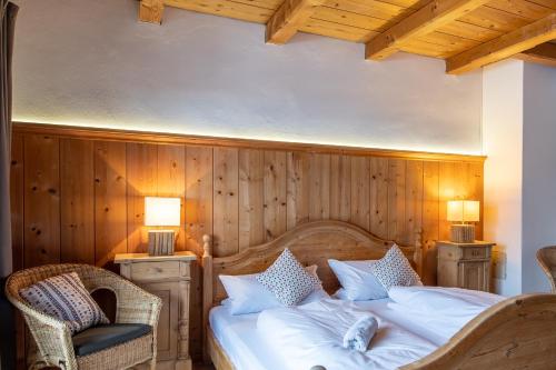 a bedroom with a bed with a wooden wall at Fischer Apartments in Oberammergau