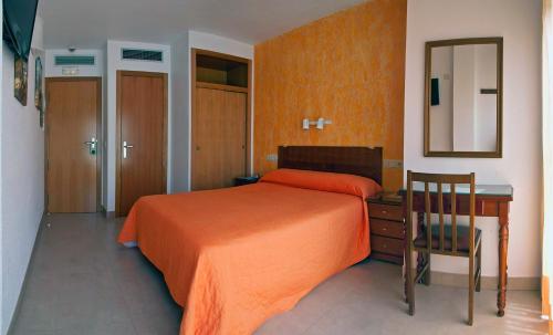 a bedroom with a bed and a desk and a mirror at Hotel Marina in Peniscola