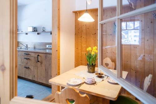 eine Küche mit einem Holztisch mit Blumen darauf in der Unterkunft Fischer Apartments in Oberammergau