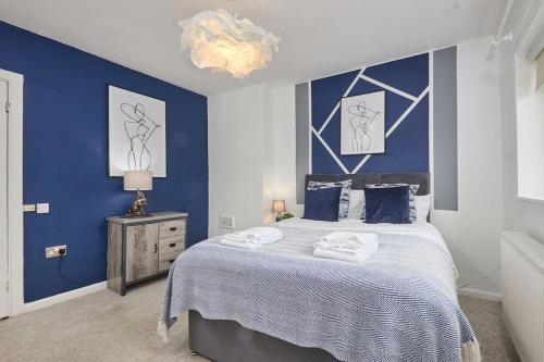 sypialnia z dużym łóżkiem z niebieskimi ścianami w obiekcie Central Nottingham house w Nottingham