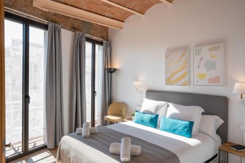 um quarto com uma cama grande e almofadas azuis em Feelathome Stadium Apartments em Hospitalet de Llobregat