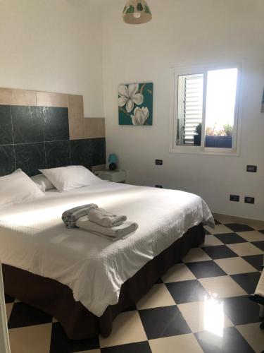 een slaapkamer met een wit bed en een zwart-witte vloer bij NATURAL CONFITAL BEACH in Las Palmas de Gran Canaria