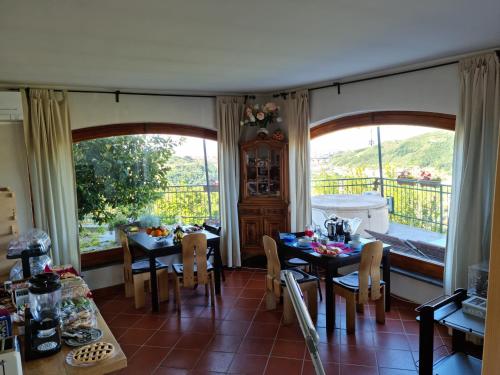 a dining room with two tables and a balcony at BeB La Terrazza Sui Fieschi in Cogorno