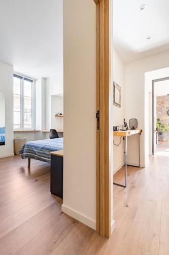 une chambre avec un lit et un bureau dans une pièce dans l'établissement Kaneta Antoni Baita - Coeur de Ville ! Classé 4 étoiles, à Hendaye