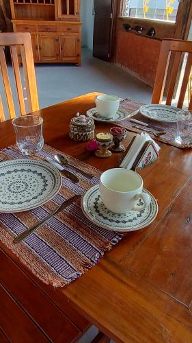 聖若昂－德雷的住宿－Pousada Hilário，木桌,上面有盘子和碗