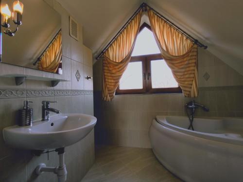 un bagno con lavandino, vasca e finestra di Willa Dzika Róża a Sandomierz