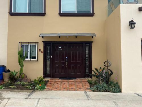 a front door of a house with a brown door at Dolphin Beach Get Away in Rosarito