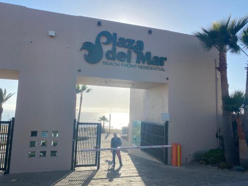 a man standing in front of a building with a sign at Dolphin Beach Get Away in Rosarito