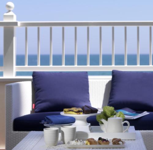 a living room with purple chairs and a table with food on it at Hotel Tiffany's in Riccione