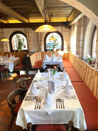 a dining room with tables with white tablecloths at Landgasthof Dorfstadl in Kössen