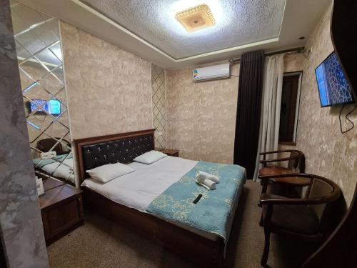 a small bedroom with a bed and a chair at Hotel Anor in Samarkand