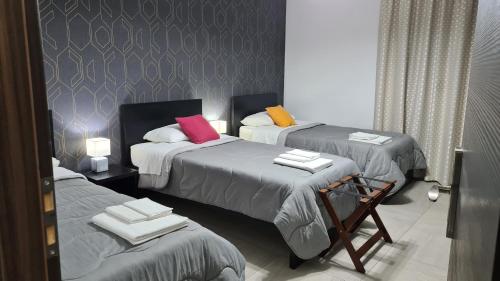 una camera con tre letti con asciugamani di Idilliaco inn a Motta SantʼAnastasia