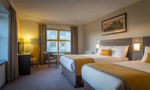 a hotel room with two beds and a television at Maldron Hotel Shandon Cork City in Cork