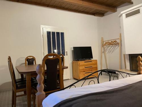 a bedroom with a bed and a table and a television at Apartmány Modrý Dom in Podhájska