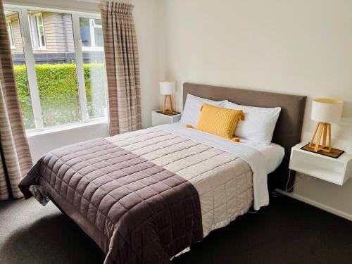 um quarto com uma cama e uma janela em Cottage on Harrogate em Hanmer Springs