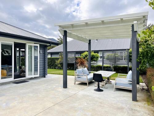a patio with chairs and a table and a pavilion at Cottage on Harrogate in Hanmer Springs