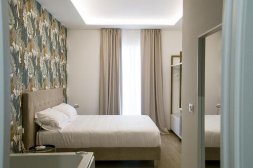 a hotel room with two beds and a window at Galileo Suite in Trani