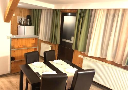 una sala da pranzo con tavolo e sedie e una cucina di Traveland Boutique Resort Poiana Brasov a Poiana Brasov