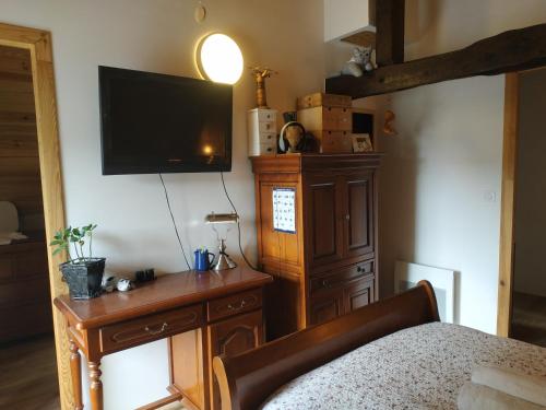 1 dormitorio con 1 cama y TV en la pared en Chambre d'hôtes dans maison éclusière, en Hennebont