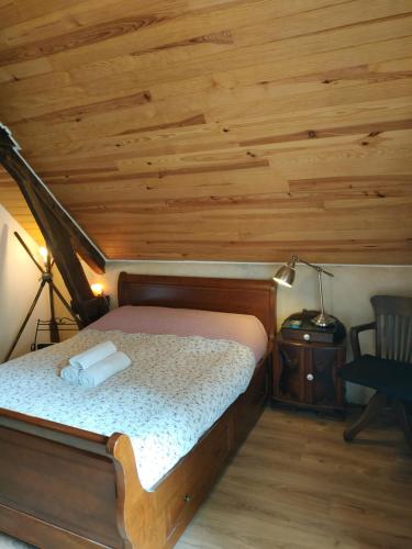 Cama en habitación con techo de madera en Chambre d'hôtes dans maison éclusière, en Hennebont