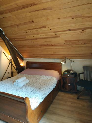 un lit dans une chambre avec un plafond en bois dans l'établissement Chambre d'hôtes dans maison éclusière, à Hennebont