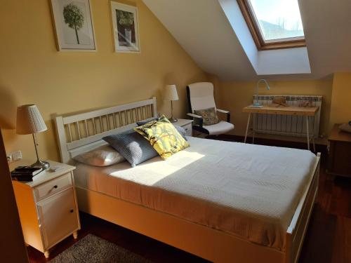a bedroom with a bed and a desk and a window at El ático de la Gorga in Boltaña