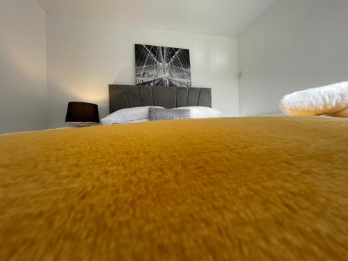 a bedroom with a large bed with a yellow blanket at Traditional with Views in Wem