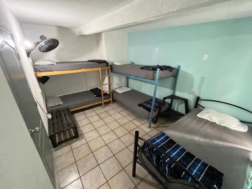 a room with two bunk beds and a tiled floor at Nómadas Hostel in La Paz