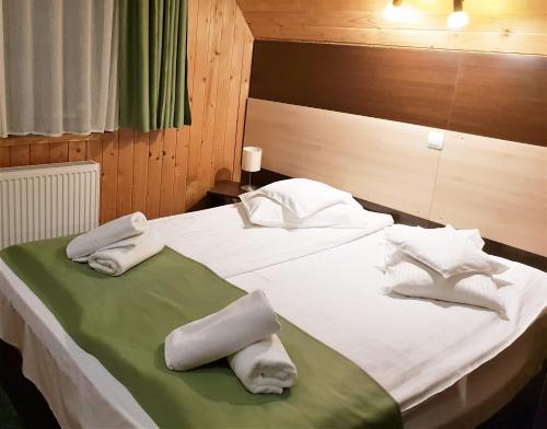 a bedroom with two beds with towels on them at Traveland Boutique Resort Poiana Brasov in Poiana Brasov