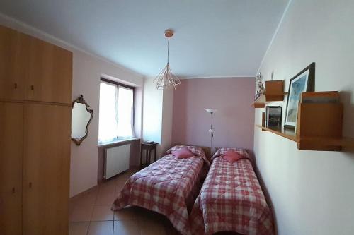 a bedroom with a bed with two pink pillows at Casa Vacanze Le tre Sorelle in Torre Pellice