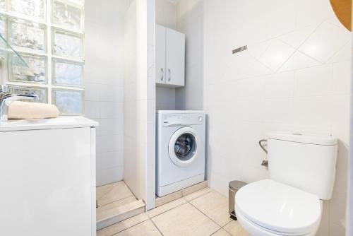 a bathroom with a toilet and a washing machine at Torremuelle - Apartment with private pool & BBQ in Benalmadena in Benalmádena