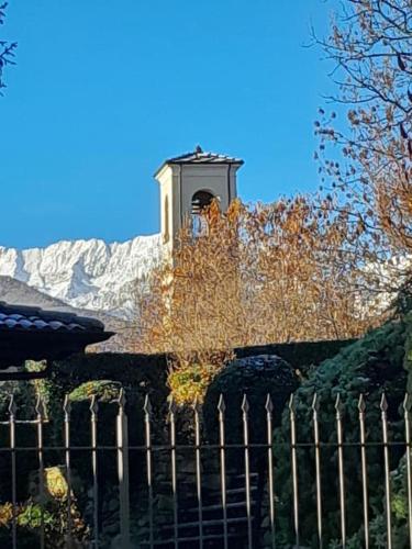 a clock tower on top of a building with a fence at Casa Vacanze Le tre Sorelle in Torre Pellice